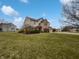 Landscaped home featuring a three car garage, green lawn, and brick exterior at 9237 Stones Ferry Pl, Indianapolis, IN 46278