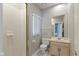 Well-lit bathroom featuring a shower, toilet, vanity, and window with blinds at 9544 Huntington Ln, Indianapolis, IN 46260
