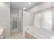 Bright bathroom featuring a jetted tub, shower, and a door to an adjacent room at 9544 Huntington Ln, Indianapolis, IN 46260