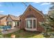 Charming brick home showcasing a cozy patio with blue outdoor furniture and a delightful sunroom addition at 9544 Huntington Ln, Indianapolis, IN 46260