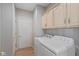 Functional laundry room with washer, dryer, and cabinetry for storage at 9544 Huntington Ln, Indianapolis, IN 46260