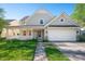 Charming two-story home with a covered porch, attached garage, and a well-manicured lawn at 9705 Shasta Dr, Fishers, IN 46038
