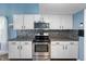 Well-lit kitchen featuring white cabinets, stainless steel appliances, and a modern backsplash at 9705 Shasta Dr, Fishers, IN 46038