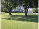 The large backyard with a detached garage, mature trees, and fencing at 10327 Old National Rd, Indianapolis, IN 46231