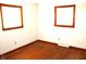 Bright bedroom featuring hardwood flooring, two windows, and ample natural light at 10327 Old National Rd, Indianapolis, IN 46231