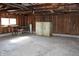View of the garage interior, showcasing concrete flooring, exposed wooden beams, and workbench at 10327 Old National Rd, Indianapolis, IN 46231