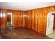 Cozy living room with rich wood paneling and hardwood floors leading to an arched doorway at 10327 Old National Rd, Indianapolis, IN 46231