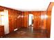 Comfortable living space with wood-paneled walls, hardwood floors, and natural light from the window at 10327 Old National Rd, Indianapolis, IN 46231