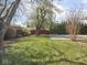 Landscaped backyard with large driveway and mature trees at 1035 N Audubon Rd, Indianapolis, IN 46219