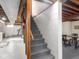 Carpeted basement stairs with wooden handrail lead to a finished space at 1035 N Audubon Rd, Indianapolis, IN 46219