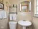 Bathroom with a pedestal sink and wall-mounted shelving at 1035 N Audubon Rd, Indianapolis, IN 46219