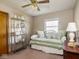Sunlit bedroom with a daybed, decorative pillows, and a vintage display shelf at 1035 N Audubon Rd, Indianapolis, IN 46219