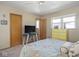 A bedroom featuring a TV, dresser and a bed with floral covers at 1035 N Audubon Rd, Indianapolis, IN 46219