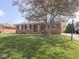 Brick ranch-style home with a mature tree and landscaped front yard at 1035 N Audubon Rd, Indianapolis, IN 46219