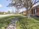 Well-kept lawn and landscaping leading to the brick facade of the home at 1035 N Audubon Rd, Indianapolis, IN 46219