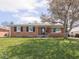 Charming brick home with a well-maintained lawn and large shade tree at 1035 N Audubon Rd, Indianapolis, IN 46219