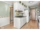 Functional galley kitchen with white cabinetry, an easy-to-clean cooktop, and wood-look flooring at 1035 N Audubon Rd, Indianapolis, IN 46219