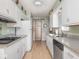 Galley kitchen featuring white cabinets, granite countertops, and appliances at 1035 N Audubon Rd, Indianapolis, IN 46219