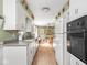 Galley kitchen with streamlined appliances and easy access to the dining room for easy meal serving at 1035 N Audubon Rd, Indianapolis, IN 46219