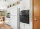 Functional kitchen with white cabinets and black oven; view to dining room at 1035 N Audubon Rd, Indianapolis, IN 46219