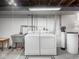 Functional laundry room with white washer and dryer, and utility sink at 1035 N Audubon Rd, Indianapolis, IN 46219