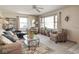 Cozy living room with plush seating, a ceiling fan, and bright natural light from the large windows at 1035 N Audubon Rd, Indianapolis, IN 46219