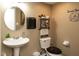 Charming powder room features a pedestal sink, round mirror, decor, and toilet with a comfortable-looking brown seat at 1083 Sugar Maple Dr, Greenwood, IN 46143