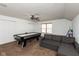 Spacious bonus room featuring an air hockey table, sectional sofa, overhead fan and a window for natural light at 1083 Sugar Maple Dr, Greenwood, IN 46143