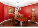 Elegant dining room with red walls, a wood table with seating for six, and a decorative flower arrangement at 1083 Sugar Maple Dr, Greenwood, IN 46143