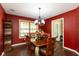 Formal dining room with hardwood floors, red walls, elegant light fixture, and large window at 1083 Sugar Maple Dr, Greenwood, IN 46143
