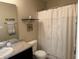 Bathroom with shower and decor on shelf above toilet and vanity with neutral countertop and dark cabinets at 10869 Spirit Dr, Ingalls, IN 46048