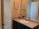 Bathroom vanity featuring framed wall decor above a neutral countertop and dark cabinets, creating a welcoming space at 10869 Spirit Dr, Ingalls, IN 46048