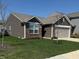 Exterior view of home with a manicured lawn, brick and siding, and two-car attached garage at 10869 Spirit Dr, Ingalls, IN 46048