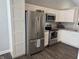 Kitchen featuring stainless steel appliances, white cabinets and dark laminate flooring at 10869 Spirit Dr, Ingalls, IN 46048