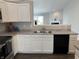 Well-lit kitchen with white cabinets, stainless steel sink and a view to the living room at 10869 Spirit Dr, Ingalls, IN 46048