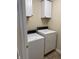 Practical laundry area featuring a side-by-side washer and dryer, and overhead storage cabinets for added convenience at 10869 Spirit Dr, Ingalls, IN 46048