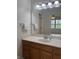 Bathroom with a wooden vanity, marble countertop, and an oversized mirror above the sink at 10949 Harness Way, Indianapolis, IN 46239