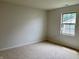 Bedroom featuring neutral carpet, a window offering natural light, and simple, cozy design at 10949 Harness Way, Indianapolis, IN 46239