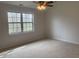 A bright bedroom with a ceiling fan and large window that lets in natural light at 10949 Harness Way, Indianapolis, IN 46239