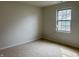Carpeted bedroom featuring a window to the outside, neutral walls, and standard electrical outlets at 10949 Harness Way, Indianapolis, IN 46239