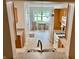 Kitchen view framed by a sink, showcasing wood cabinets, white appliances, and eat-in dining area by the window at 10949 Harness Way, Indianapolis, IN 46239