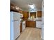 Functional kitchen with wood cabinets, white appliances, and plenty of countertop space at 10949 Harness Way, Indianapolis, IN 46239