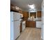 Kitchen with white appliances and light wood cabinetry with window over sink at 10949 Harness Way, Indianapolis, IN 46239