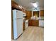 Traditional kitchen featuring wood cabinets, white appliances, and wood-look flooring at 10949 Harness Way, Indianapolis, IN 46239