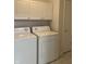 Laundry room equipped with a white washer and dryer set, and upper cabinets at 10949 Harness Way, Indianapolis, IN 46239