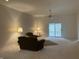 Large living room with neutral carpeting, ceiling fan, and sliding glass door to patio at 10949 Harness Way, Indianapolis, IN 46239