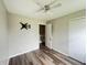 Bedroom with wood-look floors, ceiling fan and access to another room at 11147 Autumn Creek Ct, Indianapolis, IN 46229