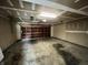 Spacious garage featuring a wooden door, overhead lighting, and concrete flooring at 11147 Autumn Creek Ct, Indianapolis, IN 46229