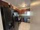 Kitchen with dark cabinetry, black appliances, and a tiled floor at 11147 Autumn Creek Ct, Indianapolis, IN 46229