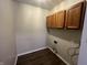A laundry room with wood-look floors and upper cabinets at 11147 Autumn Creek Ct, Indianapolis, IN 46229